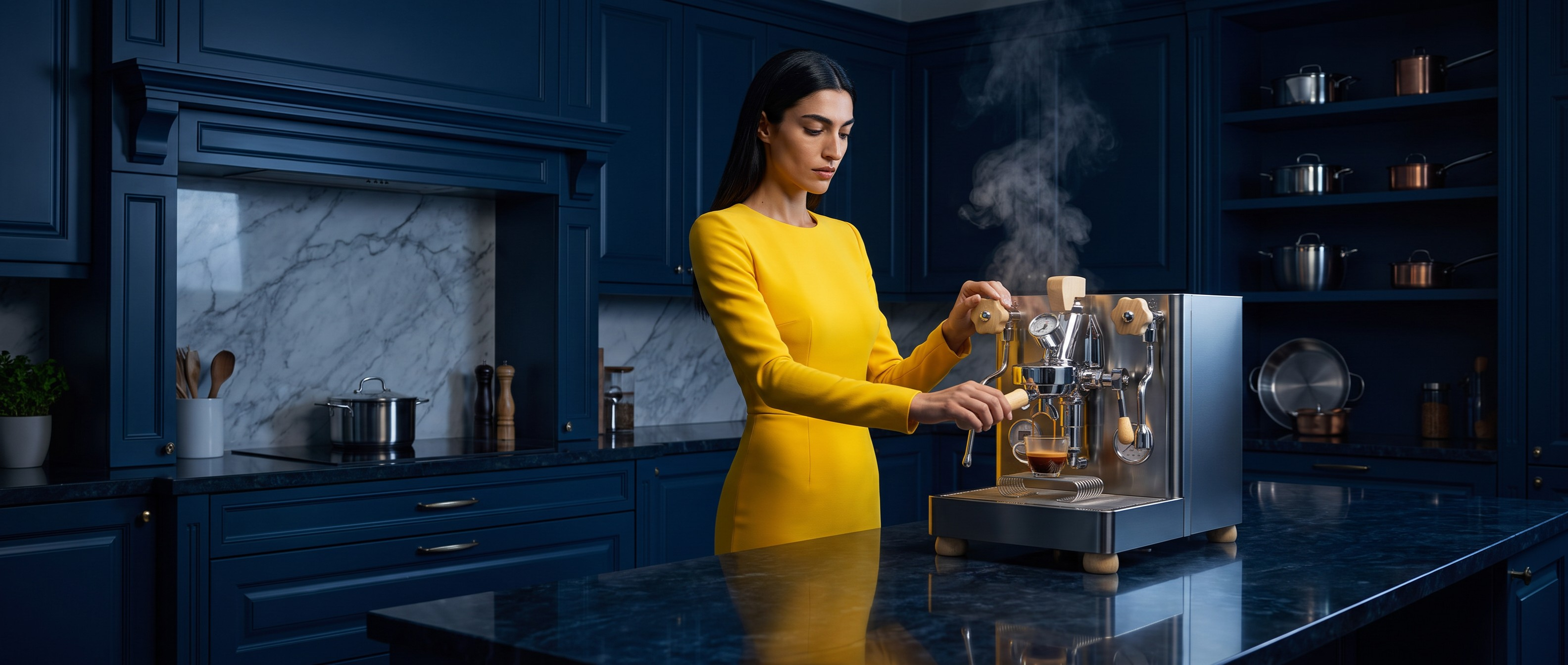 A woman in a bright yellow dress stands in a dark blue kitchen, operating a stainless steel espresso machine with steam rising from it.