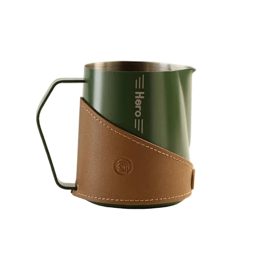 Green milk pitcher with brown leather sleeve on a white background