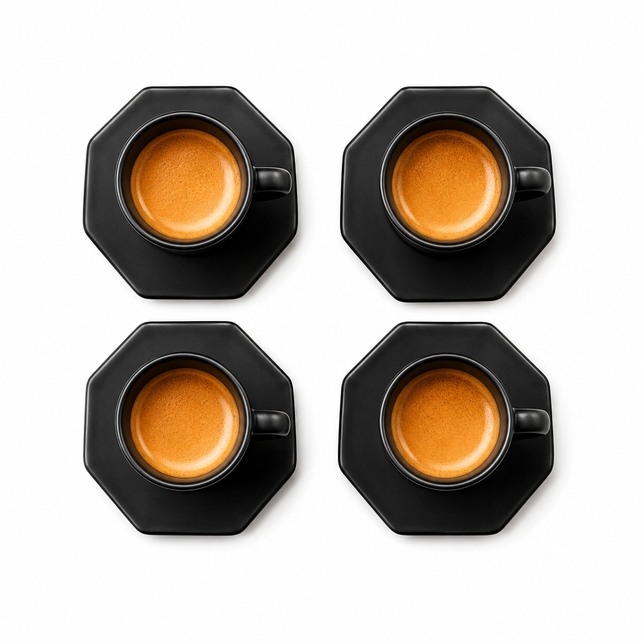 Four black octagonal coffee cups with matching saucers, each filled with espresso and topped with a layer of milk foam, arranged in a 2x2 grid on a white background.